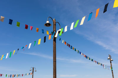 Low angle view of flags hanging against sky