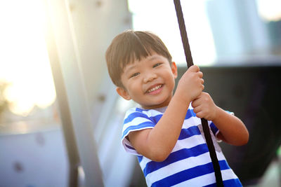 Portrait of smiling boy swinging on swing