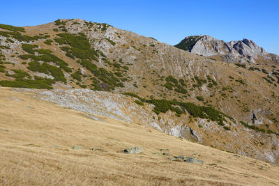 Scenic view of rocky mountains against clear blue sky