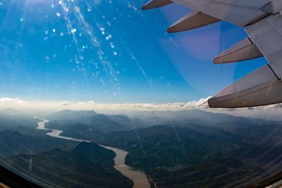 Landscape seen through airplane window against sky