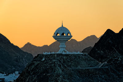 Traditional windmill against clear sky during sunset