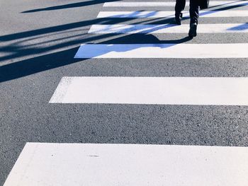 Low section of man crossing road