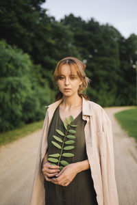 Woman in the countryside with a green branch in her hands