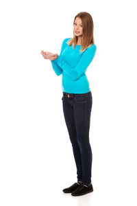 Portrait of young woman standing against white background