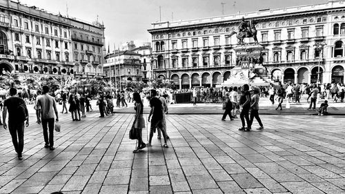 People on street against buildings in city