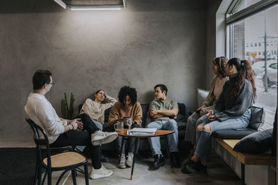 Multiracial male and female business colleagues discussing during break at creative office