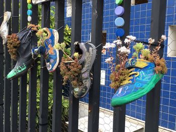 Various sculpture on railing against fence