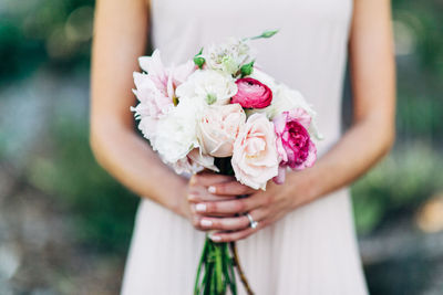 Midsection of woman holding flower bouquet