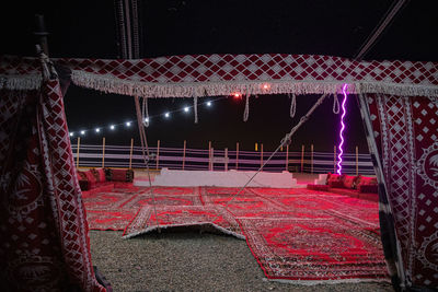 Low angle view of illuminated lighting equipment hanging at night