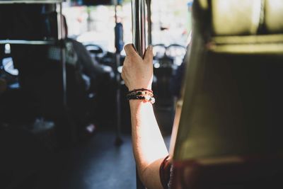 Cropped hand of person holding pole in bus