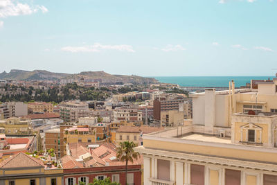 High angle view of townscape by sea against sky