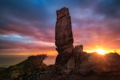 Rock formation against sky during sunset