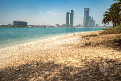 Sea by buildings against sky in city in abu dhabi