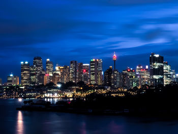 Illuminated buildings in city against sky at night
