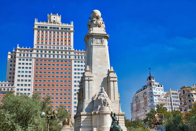 Low angle view of statue against buildings