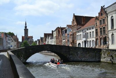 Bridge over river in city against sky