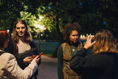 Young woman standing against people