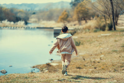 Portrait of child running near a lake