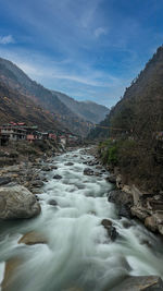 Scenic view of river amidst mountains against sky