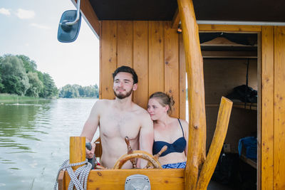 Couple sitting in boat over river