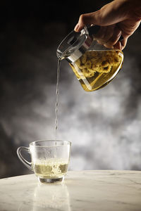 Midsection of person pouring drink in glass