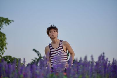 Full length of man standing on field against sky in purple flowers field