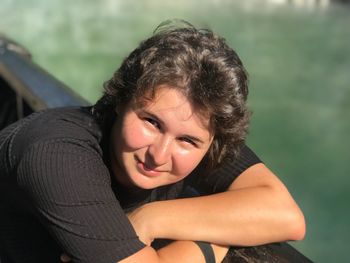 Close-up portrait of woman smiling against river