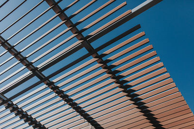 Low angle view of shade structure against clear blue sky