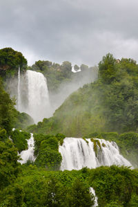 Scenic view of waterfall against sky