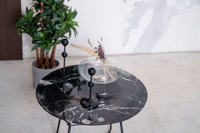Round granite black table. black candlesticks on a black glossy table loft interior