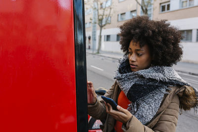 Young woman looking down while standing in bus