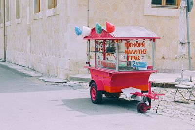 Red cart on street by building