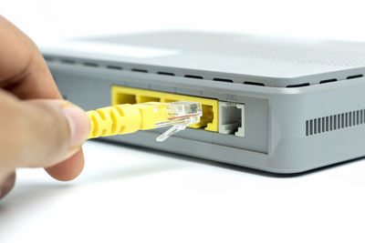 Midsection of man using cable on hard drive over white background