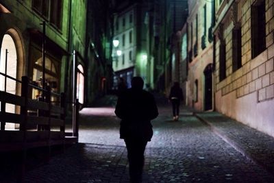 Full length of woman standing in illuminated building at night