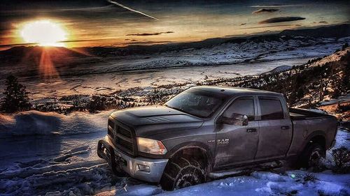 Abandoned car on snow during sunset