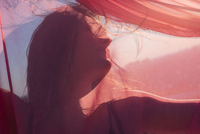 Close-up of young woman with pink scarf