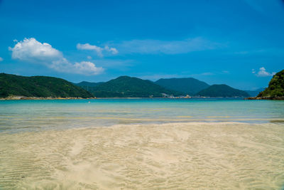 Scenic view of beach against blue sky