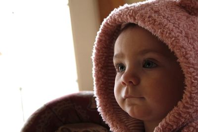 Cute baby girl in knit hat at home