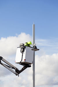 Person stands in a basket and fixes street lighting