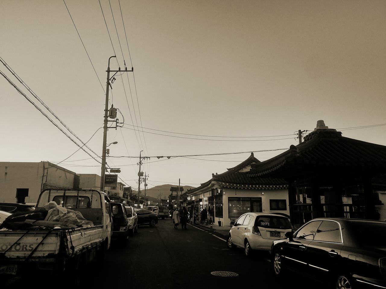 CARS ON ROAD AGAINST CLEAR SKY IN CITY