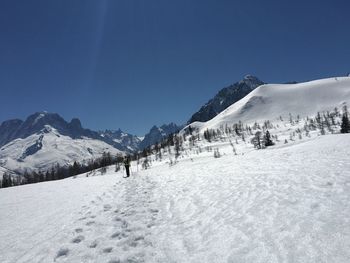 Scenic view of snowcapped mountains against clear blue sky