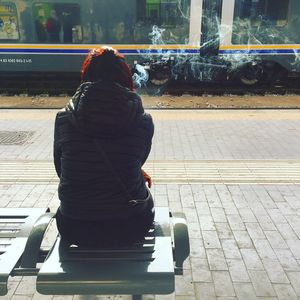 Rear view of woman with umbrella in city