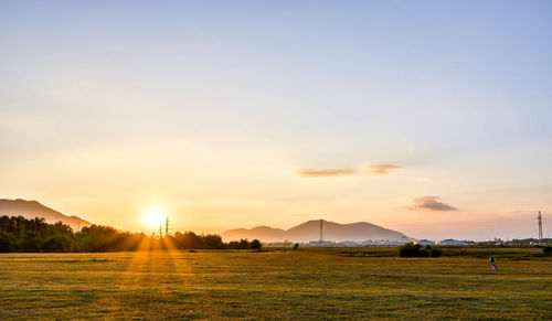 Scenic view of field against sky during sunset