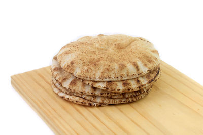 Close-up of cookies on cutting board against white background