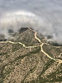 Aerial view of land against cloudy sky