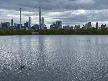 View of lake and buildings against sky