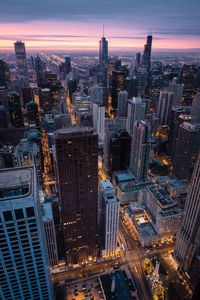 High angle view of city lit up at sunset