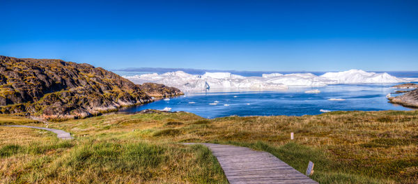 Scenic view of calm sea against clear blue sky