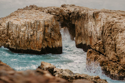Scenic view of rocks in sea against sky