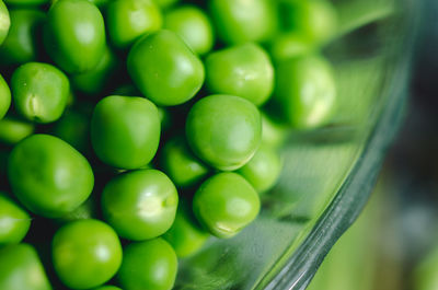 A close-up of green peas in a glass bowl